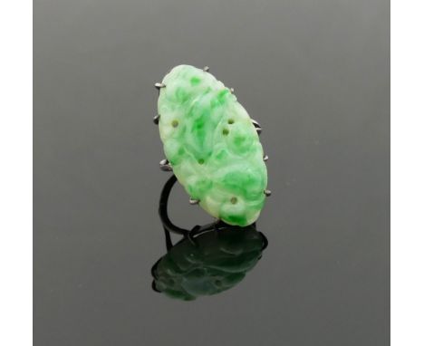 A late 19th/early 20th century Chinese jade panel ring, the oval carved and pierced panel, 3.2cm x 1.7cm, within claw setting