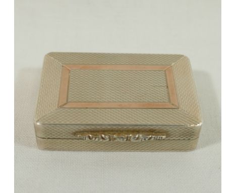 A rectangular silver pill box with gilt interior and engine turned decoration, ornate cast thumb piece and rose gold detail t