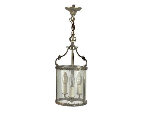 A 20th century cast metal circular lantern. With triple light fittings and C scroll supports, height 56cm.