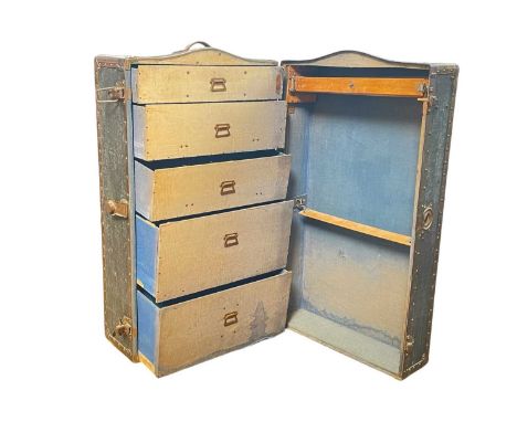 A 1920s Innovation wardrobe steamer trunk. With applied metal label, fitted with drawers and hanging space, height 103cm.One 