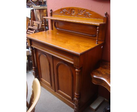 A late Victorian walnut chiffonier, the raised foliate carved back with shelf on turned supports above a long frieze drawer a