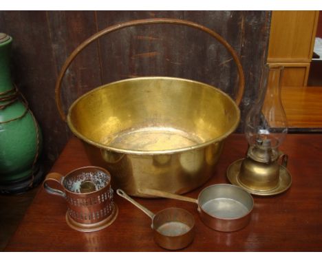 A brass pan with steel handle, oil lamp, pierced copper candle stand and two miniature pans. 