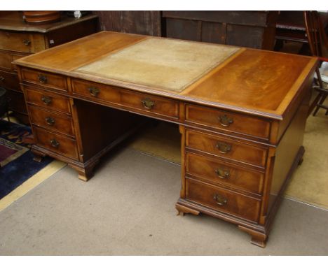 A 20th Century reproduction early 18th Century style walnut twin pedestal desk, the top inset with leather to centre over an 