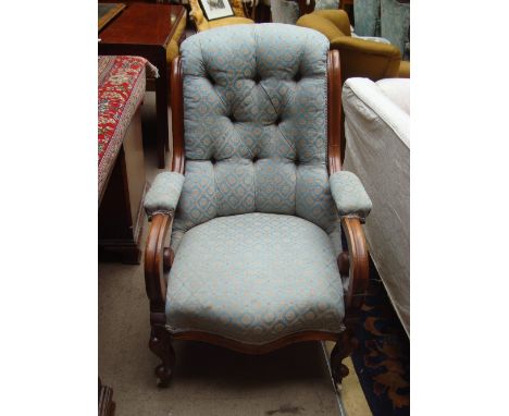 A Victorian walnut armchair with moulded frame, buttoned scroll back, padded scrolled arms and serpentine fronted seat, raise