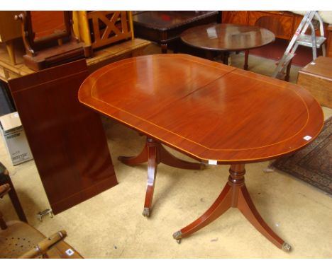 Peter Spicer.  A George III style small mahogany twin pedestal dining table with D ends, strung, raised on turned stem and ou