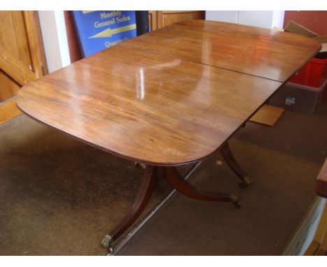 A 19th Century and later mahogany twin pedestal dining table, the top with rounded ends, moulded edge and extra leaf on turne