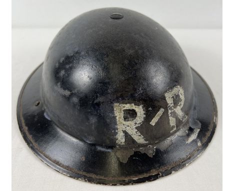 A British WWII Home Front MkII steel helmet painted with white letters R/R. Helmet stamped BMB 1939, painted black over khaki