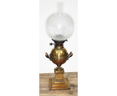 A Hinks brass oil lamp of urn form on column with weighted and stepped base, glass shade and flu, total height 64cm.&nbsp;Con