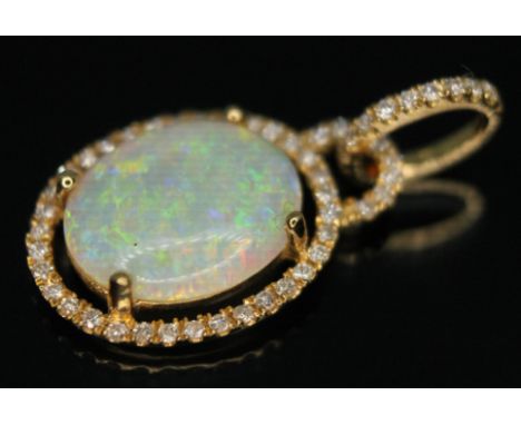 A precious opal and diamond pendant, the cnetral cabochon measuring approx. 12mm x 10mm x 2mm, pendant length 25mm, marked 18