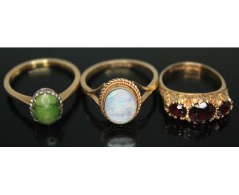 A group of three rings comprising a green cabochon ring marked 18ct, a ring set with an opal triplet marked 9ct Gold and a ha