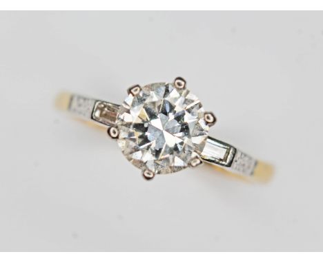 A diamond solitaire ring, the six claw set round brilliant cut diamond weighing approx. 1 carat (estimated), baguette cut dia