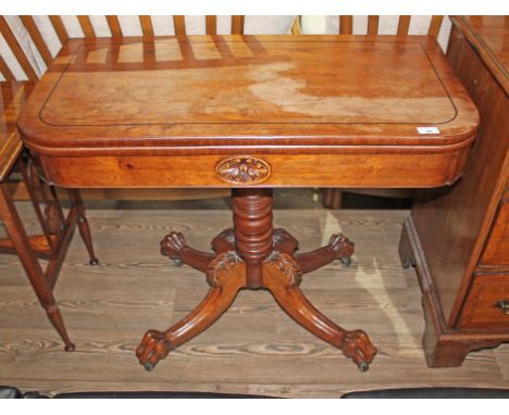 A Regency rosewood fold-over card table, frieze with card oval, turned pedestal, four out-splayed legs with acanthus carved k