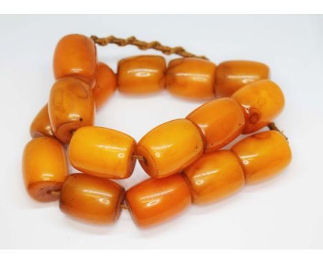 A single strand of large barrel shaped slightly marbled butterscotch bakelite beads, length approx. 28mm to 30mm each, total 