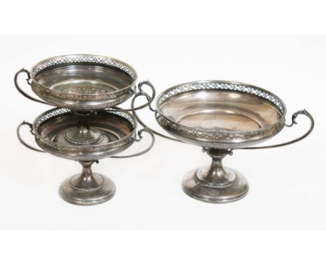 A set of three matching silver tazzas, each with twin handles and pierced border, pedestal bases, the smaller pair length 24c