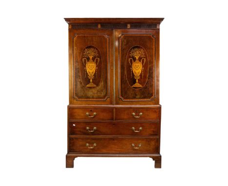 A George III mahogany and inlaid linen press. With a fluted cornice above a pair of urn inlaid doors enclosing sliding shelve