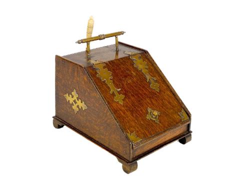 An early 20th century brass bound oak novelty tea caddy. Modelled as a slope fronted coal box with brass and bone scoop, heig