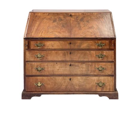 A George III mahogany bureau. Full front opens to reveal an arrangement of drawers and compartments. Over four long drawers r