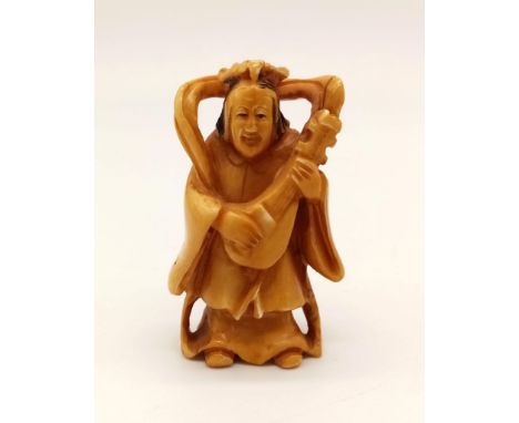 A 19th Century, Japanese, carved ivory netsuke of a musician. Height: 5.2 cm, weight: 25 g. 