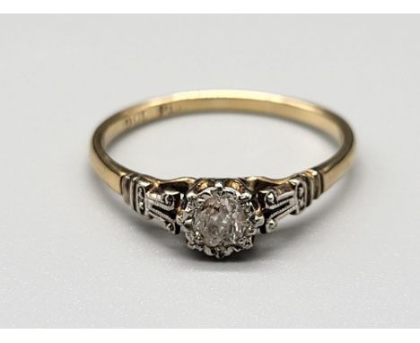 A 9 K yellow gold and platinum ring with a single diamond. 