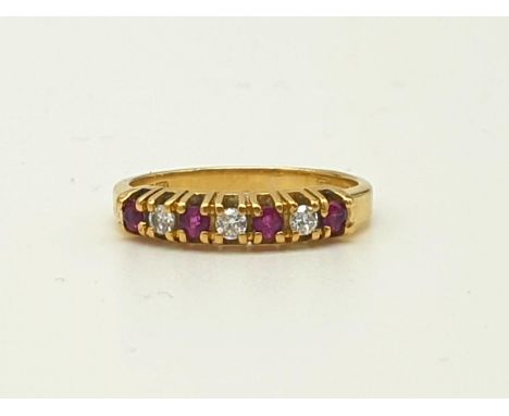An 18K Yellow Gold Ruby and Diamond Ring. Seven stones. Size I. 2.27g 