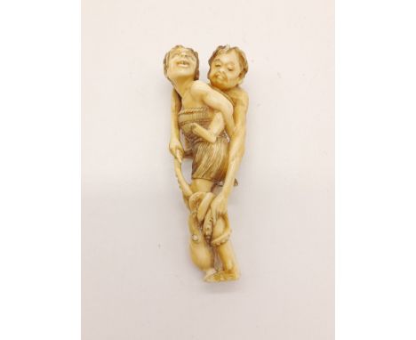 A 19th Century carved ivory Netsuke figure of a mother and child catching an octopus. Height: 8 cm, weight: 26 g. 