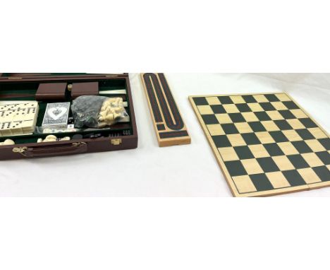 A WOODEN GAMES CONPENDUIM, BACKGAMMON, DRAUGHTS, CHESS, DOMINOES AND PLAYING CARDS. IN A FAUX LEATHER TRAVEL BOX. 