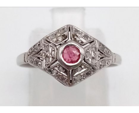 An art Deco 18 K white gold ring with a ruby surrounded by diamonds. Ring size: M/N, weight: 1.8 g. 