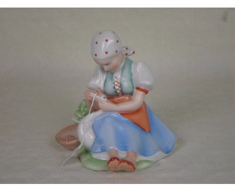 A 20th century Zsolnay Pecs ceramic figurine of a seated girl with a goose, printed and painted marks to base, 17cm.