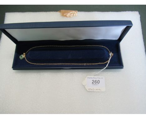 An emerald, diamond and enamel rectangular pendant on an associated 9ct gold rope twist chain.