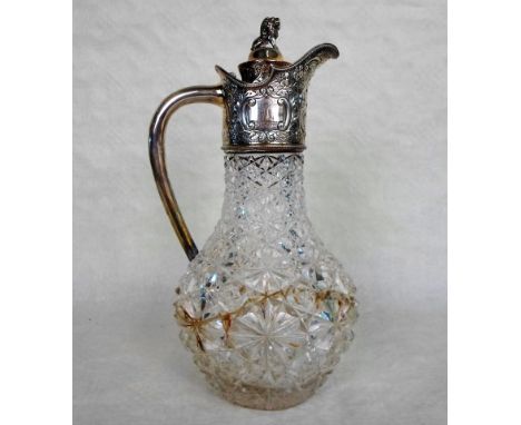 A late Victorian cut glass claret jug, the silver mount having chased decoration with engraved cartouche and seated lion fini