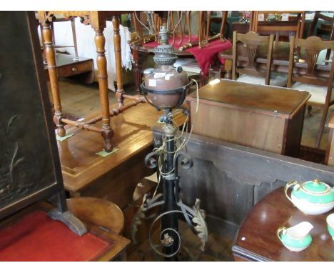 A late Victorian floor standing oil lamp of scrollwork form, later converted to electricity, 136cm.