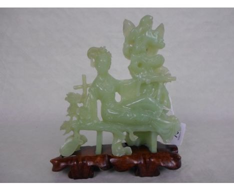 A Chinese Celadon jade study of a lady reclining on a bench, 18cm, mounted to bespoke hardwood base.