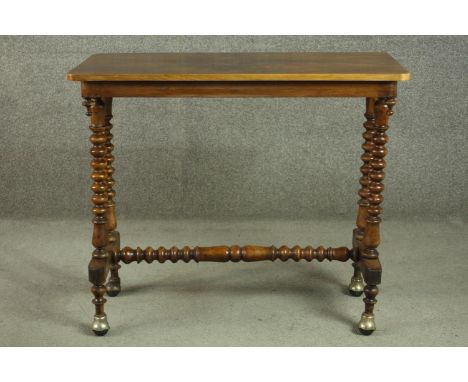 A Victorian figured walnut stretcher table, the quarter veneered top on bobbin turned legs joined by a bobbin turned stretche