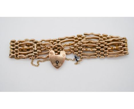 A Victorian yellow metal (tests as 9 carat gold) gate leg bracelet with heart shaped padlock clasp stamped 9ct and safety cha