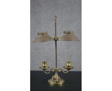 A 19th century brass double rise and fall student's candle lamp with scrolled arm supports. H.49 W.35cm 