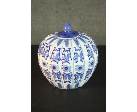 A blue and white Chinese ceramic gourd form lidded jar with stylised floral design and character mark to base. H.28 W.27cm 