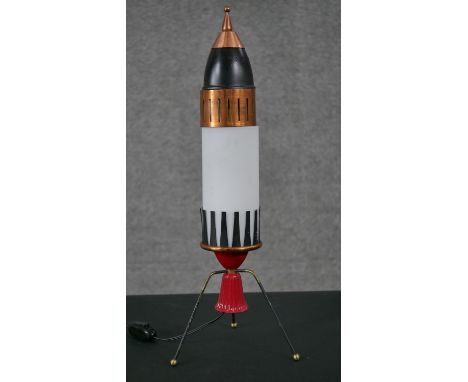 A vintage painted metal rocket ship table lamp on tripod legs. H.49 W.18 D.18cm 