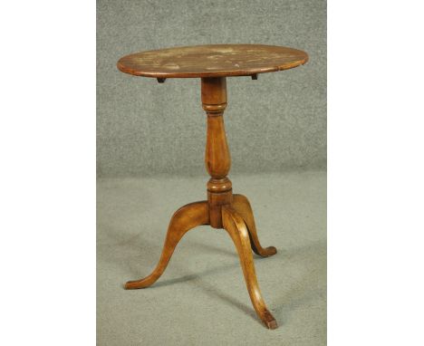 A 19th century oval tilt top tripod table, with a turned stem. H.70 W.52 D.37cm 