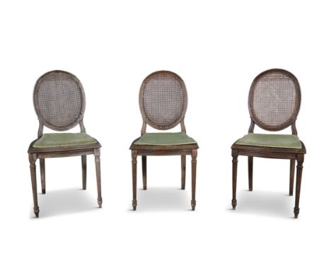 A SET OF THREE NINTEENTH CENTURY STAINED BEECH FRAMED SIDE CHAIRS, with oval panel cane backs and seats, raised on turned ree