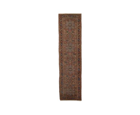 AN ANTIQUE HERIZ RUNNER, NORTH WEST PERSIA. 417 x 99CMwith seven linked shield shaped medallions within a main border of serr
