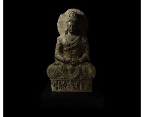 2nd-4th century AD. Depicted in meditation with a contemplative expression, seated above a figural pedestal, this schist scul