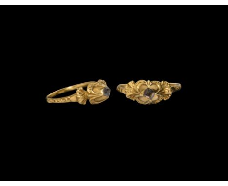 16th century AD. A gold finger ring with slender hoop, scroll detailing to the shoulders and conical bezel, inset diamond.  3