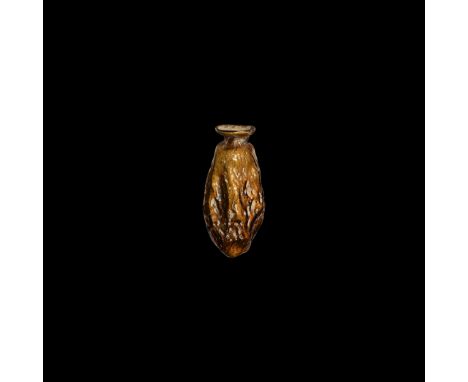 2nd-3rd century AD. A mould-blown flask with elliptical body, short neck and thick everted rim in amber-tinted glass, the bod