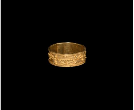 16th century AD. A gold finger ring comprising a flat hoop with filigree cable borders, median band of beaded wire lozenges w