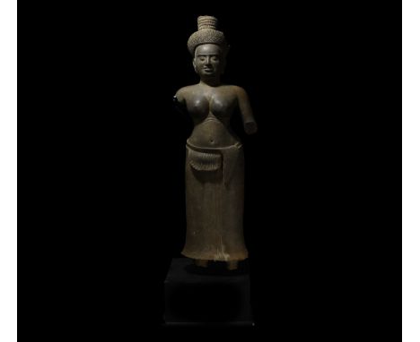 10th-13th century AD. A carved grey sandstone statue of a female deity, probably Lakshmi, wearing a long pleated sampot with 