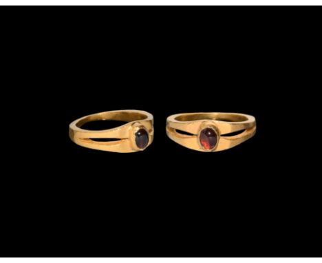 17th century AD. A gold finger ring with split shoulders, cell with inset garnet cabochon.  5.49 grams, 19.96mm overall, 15.8