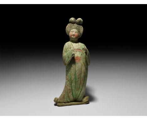 Tang Dynasty, 618-906 AD. A ceramic figure of a lady in floor-length courtly dress with left hand exposed and right hand held