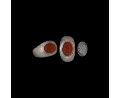 2nd-early 3rd century AD. A silver finger ring with tapering shoulders, domed plaque with inset carnelian gemstone, intaglio 