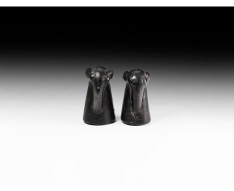 19th-20th century AD. A group of two carved jet chess pieces, each an elephant's head and neck with extended trunk and lobed 
