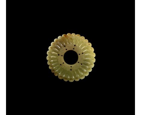 18th-19th century AD. A carved jade annular plaque comprising an outer ring of round dished panels beside scooped radiating b